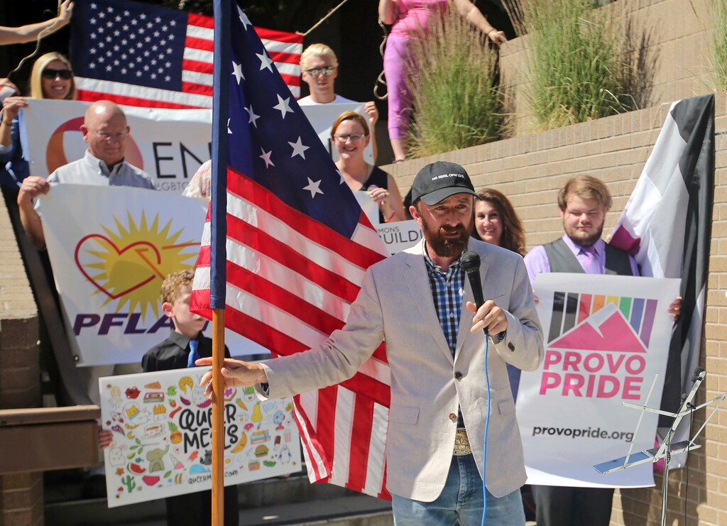 (Rick Bowmer | AP) Utah County Commissioner Nathan Ivie speaks as he holds the American flag during a news conference to discuss the America's Freedom Festival's decision Thursday, June 14, 2018, in Provo, Utah. LGBT groups that were denied requests to participate in a July 4 parade that is part of America's Freedom Festival in Provo spoke out Thursday about being rejected even after festival organizer and Provo city officials signed a nondiscrimination deal.