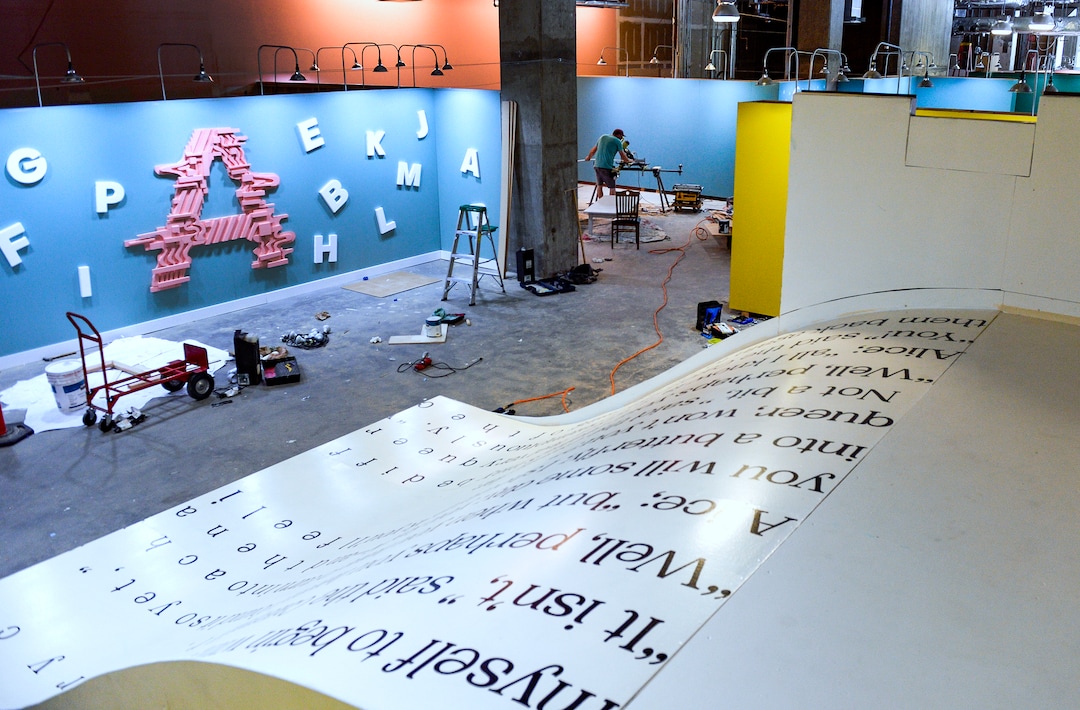 (Leah Hogsten  |  The Salt Lake Tribune)  Matt McDowell cuts wood strips to nail on the bottom of the giant book replica slide from a page of “Alice in Wonderland” at the Love Letters Museum show opening June 21, 2109. Love Letters is the newest 15,000-square-foot interactive art installation at The Gateway dedicated to the love of letters, as well as typography, books and literal love letters. “It is our attempt to use what we know best (letters, words, and art) to encourage each of our visitors to find and tell their own story. And to find the art in other's stories” -Love Letters Museum. ​