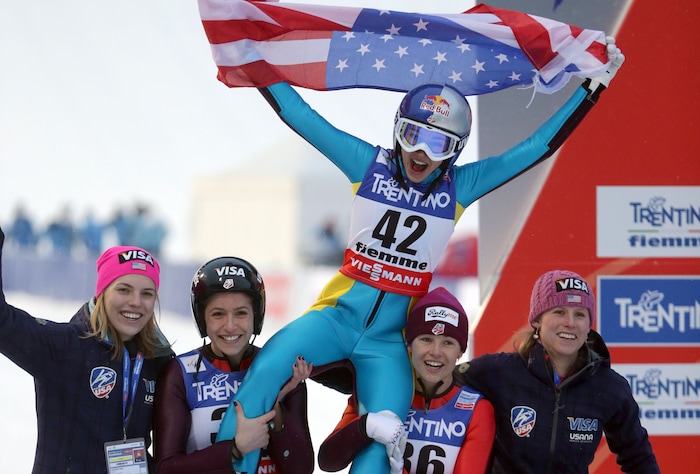 Sarah Hendrickson of the United States celebrates with teammates after winning the women's ski jumping HS 106 Individual at the Nordic Ski World Championships in Val di Fiemme, Italy, Friday, Feb. 22, 2013.  (AP Photo/Matthias Schrader)