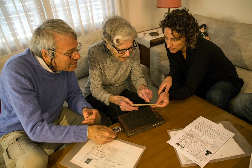 (Tsafrir Abayov | The Associated Press) In this Tuesday, April 23, 2019 photo, Israeli Holocaust survivors Rachel Zeiger 91, center, and her brother Moshe Akerman 84, left, speak with Orit Noiman, head of Yad Vashem's collection and registration center, at their home at the city of Ramat Gan, Israel. With the world's community of aging Holocaust survivors rapidly shrinking, and their live testimonies soon to be a thing of the past, Israel’s Yad Vashem Holocaust memorial is preparing for a world without them.