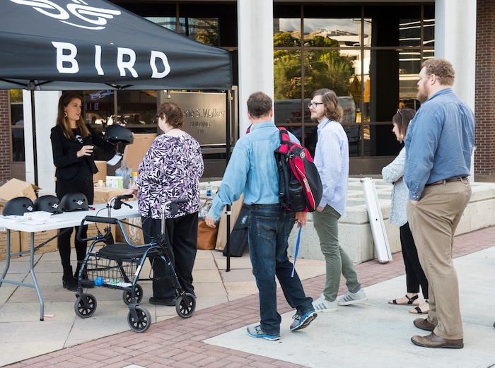 (Rick Egan  |  The Salt Lake Tribune)      People line up for free helmets courtesy of Bird scooters, after a news conference, about the new campaign with e-scooter companies Lime and Bird in an effort to help residents and visitors understand the rules of the sidewalk, Wednesday, Oct. 3, 2018.


