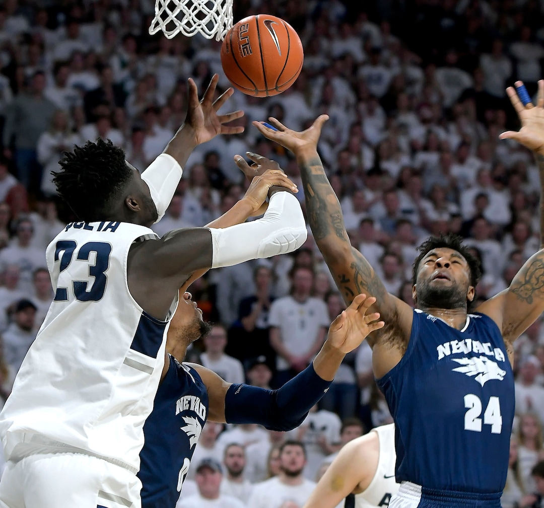 (Eli Lucero  |  The Herald Journal via AP) Utah State center Neemias Queta (23) fights for a rebound against Nevada forward Tre'Shawn Thurman (0) and forward Jordan Caroline (24) during an NCAA college basketball game, Saturday, March 2, 2019, in Logan, Utah.