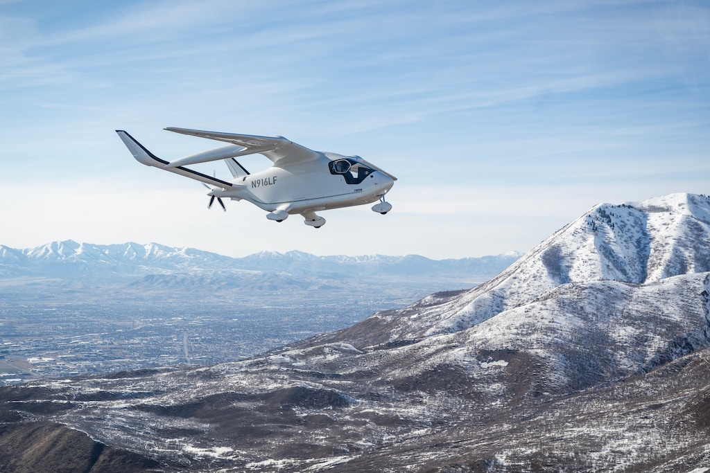 (BETA Technologies) BETA Technologies’ ALIA CX300 electric aircraft flies over the Wasatch Mountains in a March 2025 demonstration.