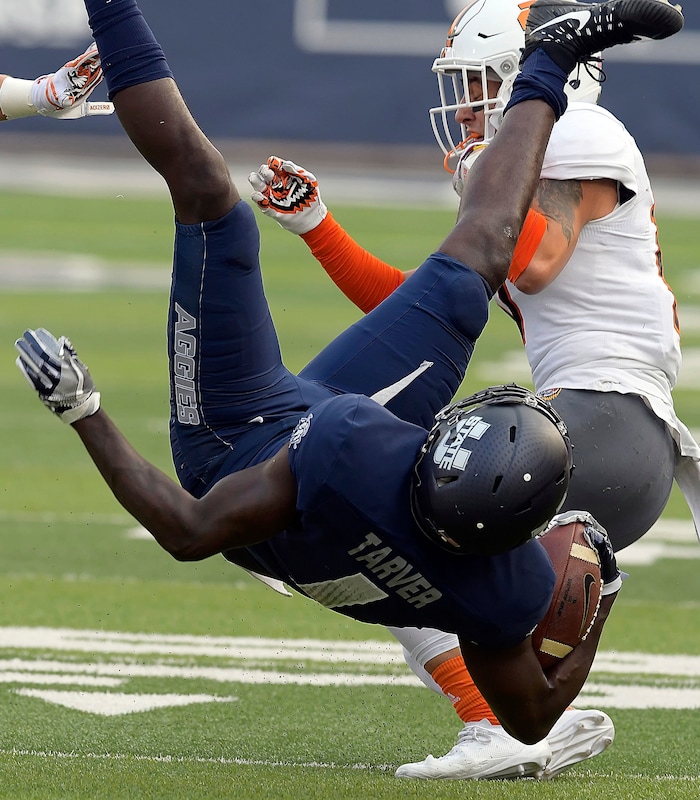 Utah State wide receiver Ron'quavion Tarver (1) is upended by Idaho State defensive back Tucker Louie-McGee during an NCAA football game Thursday, Sept. 7, 2017, in Logan, Utah. (Eli Lucero/Herald Journal via AP)