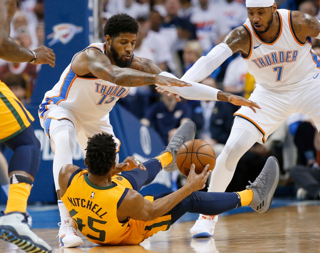 Oklahoma City Thunder forwards Paul George (13) and Carmelo Anthony (7) try to keep Utah Jazz guard Donovan Mitchell (45) from passing the ball during the first half of Game 2 of an NBA basketball first-round playoff series in Oklahoma City, Wednesday, April 18, 2018. (AP Photo/Sue Ogrocki)