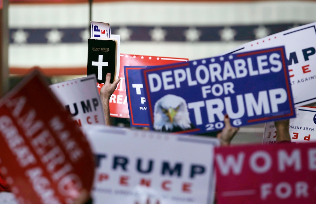 FILE - In this Monday, Nov. 7, 2016 file photo, supporters hold signs and a copy of the Bible during a rally for Republican presidential candidate Donald Trump in Manchester, N.H. For the combatants in America's long-running culture wars, the triumph of Donald Trump and congressional Republicans was stunning _ sparking elation on one side, deep dismay on the other. (AP Photo/Charles Krupa)