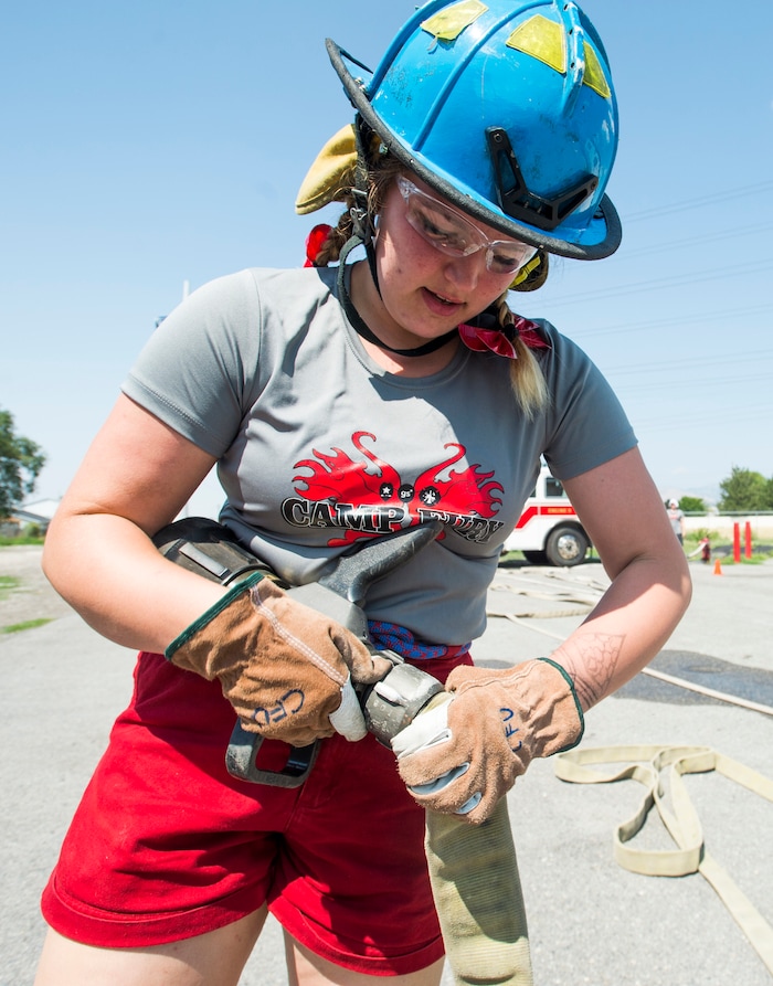 (Rick Egan  |  The Salt Lake Tribune)  Shelby hooks a nozzle up to a hose, during a firefighting skills relay while attending Camp Fury.  A dozen Utah Girl Scouts participated in a 3-day camp led by female firefighters. Camp Fury Utah was developed in partnership with the Girl Scouts and local fire and police departments, designed to expose teen girls to careers in public safety and other non-traditional jobs. Saturday, August 5, 2017.


