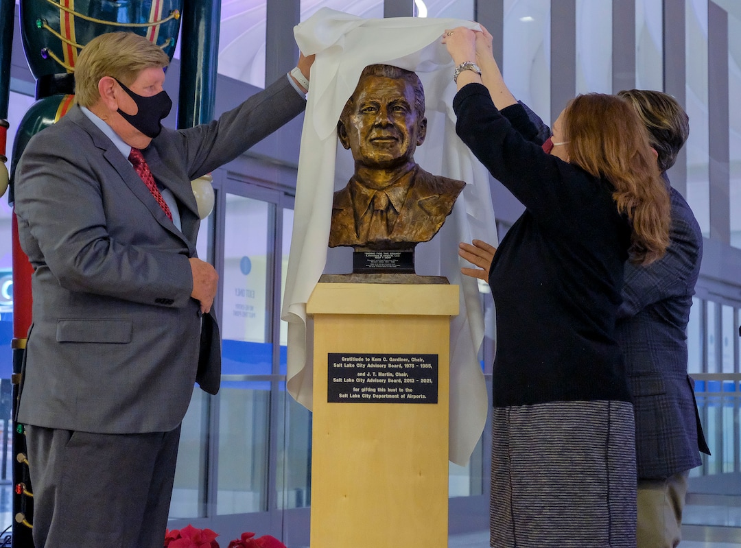(Leah Hogsten  |  The Salt Lake Tribune) Salt Lake City International Airport commemorated its 100-year anniversary with a bust unveiling of Lawrence H. Lee, Dec. 21, 2020. l-r Kem C. Gardner, Laura Lee and J.T. Martin unveil the statue. Lee was the former CEO of Western Airlines, who was responsible for converting what had been a medium-sized airport in 1983 into the nationÕs 23rd busiest with 99 nonstop destinations.