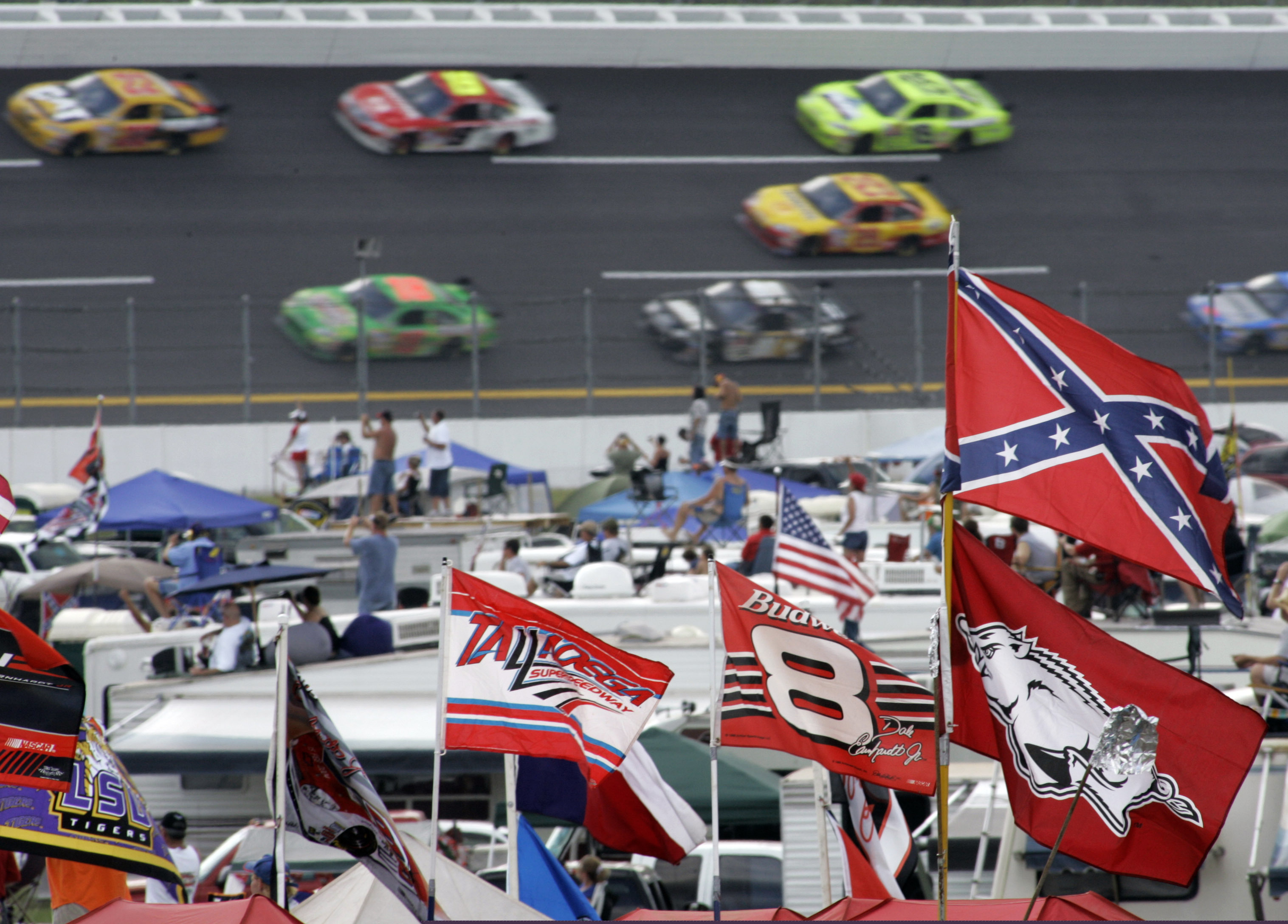 (Rob Carr | AP file photo) In this Oct. 7, 2007, file photo, a Confederate flag flies in the infield as cars come out of Turn 1 during a NASCAR auto race at Talladega Superspeedway in Talladega, Ala. NASCAR banned the Confederate flag from its races and venues Wednesday, June 10, 2020, formally severing itself from what for many is a symbol of slavery and racism.