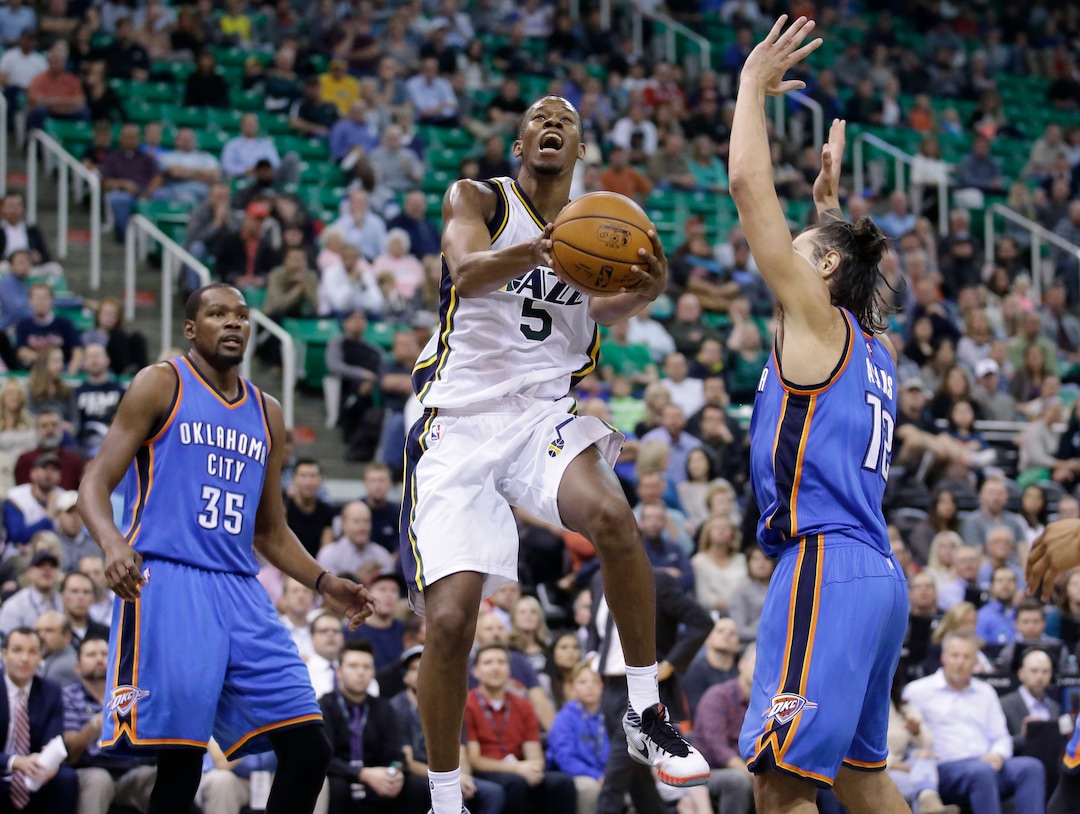 Utah Jazz guard Rodney Hood (5) goes to the basket between Oklahoma City Thunder's Steven Adams (12) and  Kevin Durant (35) during the second quarter of an NBA preseason basketball game Tuesday, Oct. 20, 2015, in Salt Lake City. The Thunder won 113-102. (AP Photo/Rick Bowmer)