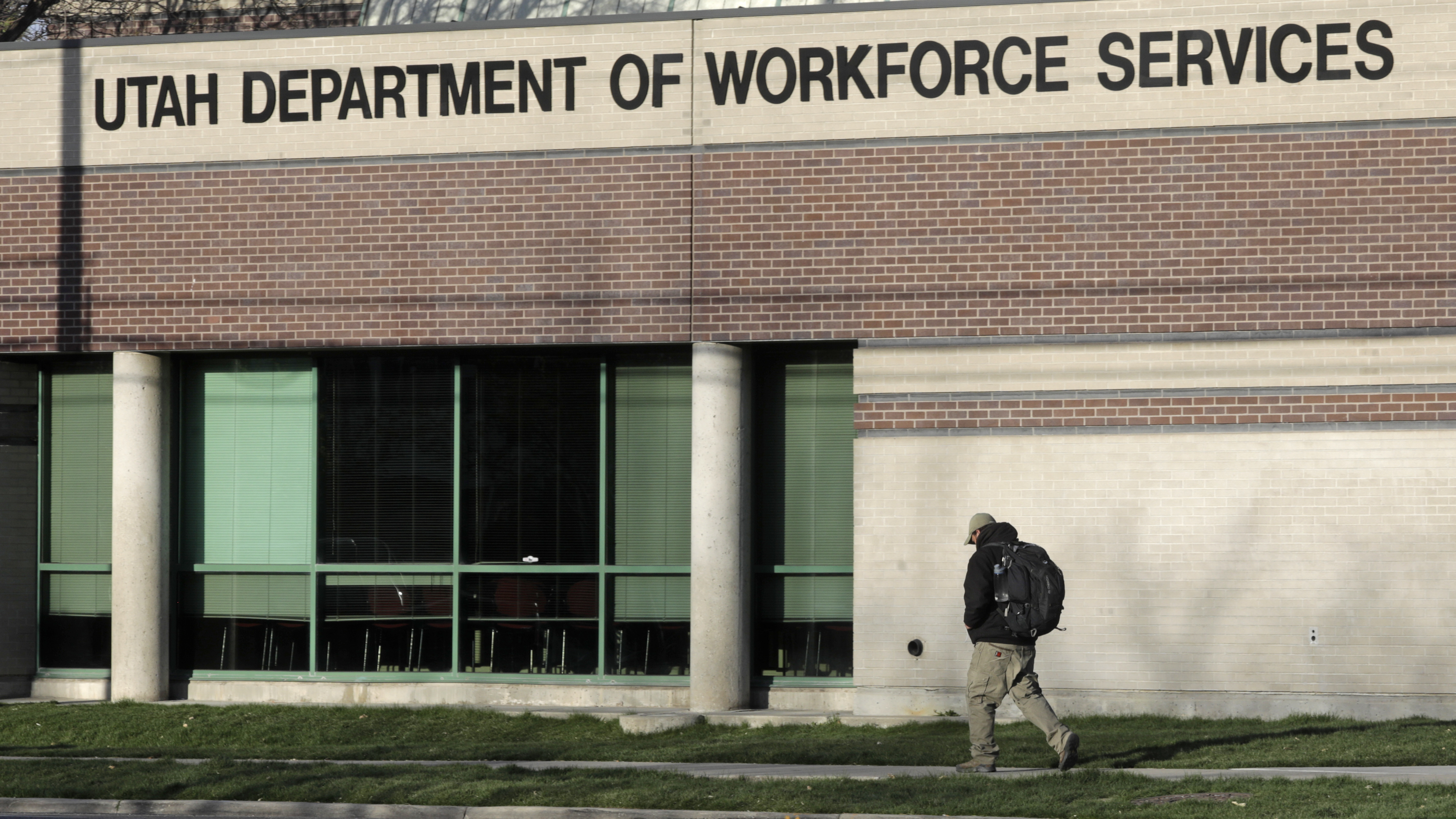 (Rick Bowmer | AP file photo) A man walks past the Utah Department of workforce Services, April 9, 2020, in Salt Lake City. With a startling 6.6 million people seeking unemployment benefits last week, the United States has reached a grim landmark: More than one in 10 workers have lost their jobs in just the past three weeks to the coronavirus outbreak.