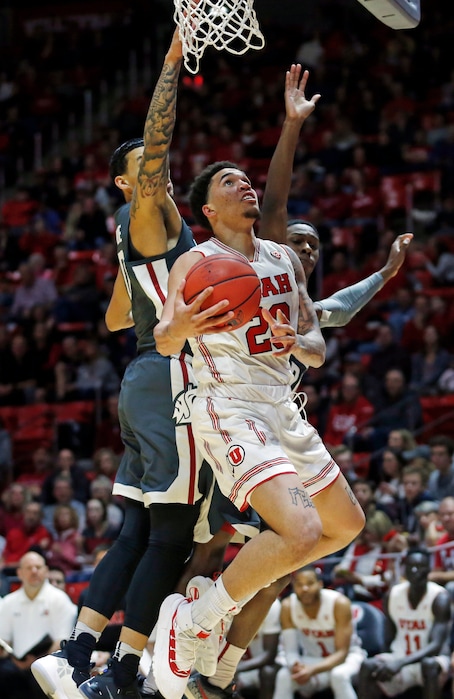 (AP Photo/Rick Bowmer) Utah forward Timmy Allen (20) goes to the basket as Washington State's Isaiah Wade, left, and Viont'e Daniels, right, defend during the second half of an NCAA college basketball game Saturday, Jan. 12, 2019, in Salt Lake City.