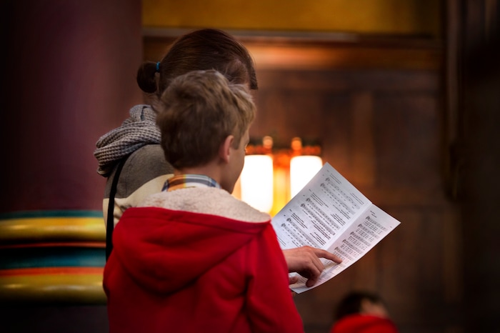 (Scott Sommerdorf   |  The Salt Lake Tribune)   A mother and son follow along together as they sing a hymn during the early morning Christmas Eve mass on the fourth Sunday of Advent at the Cathedral of the Madeleine, Sunday, December 24, 2017. 