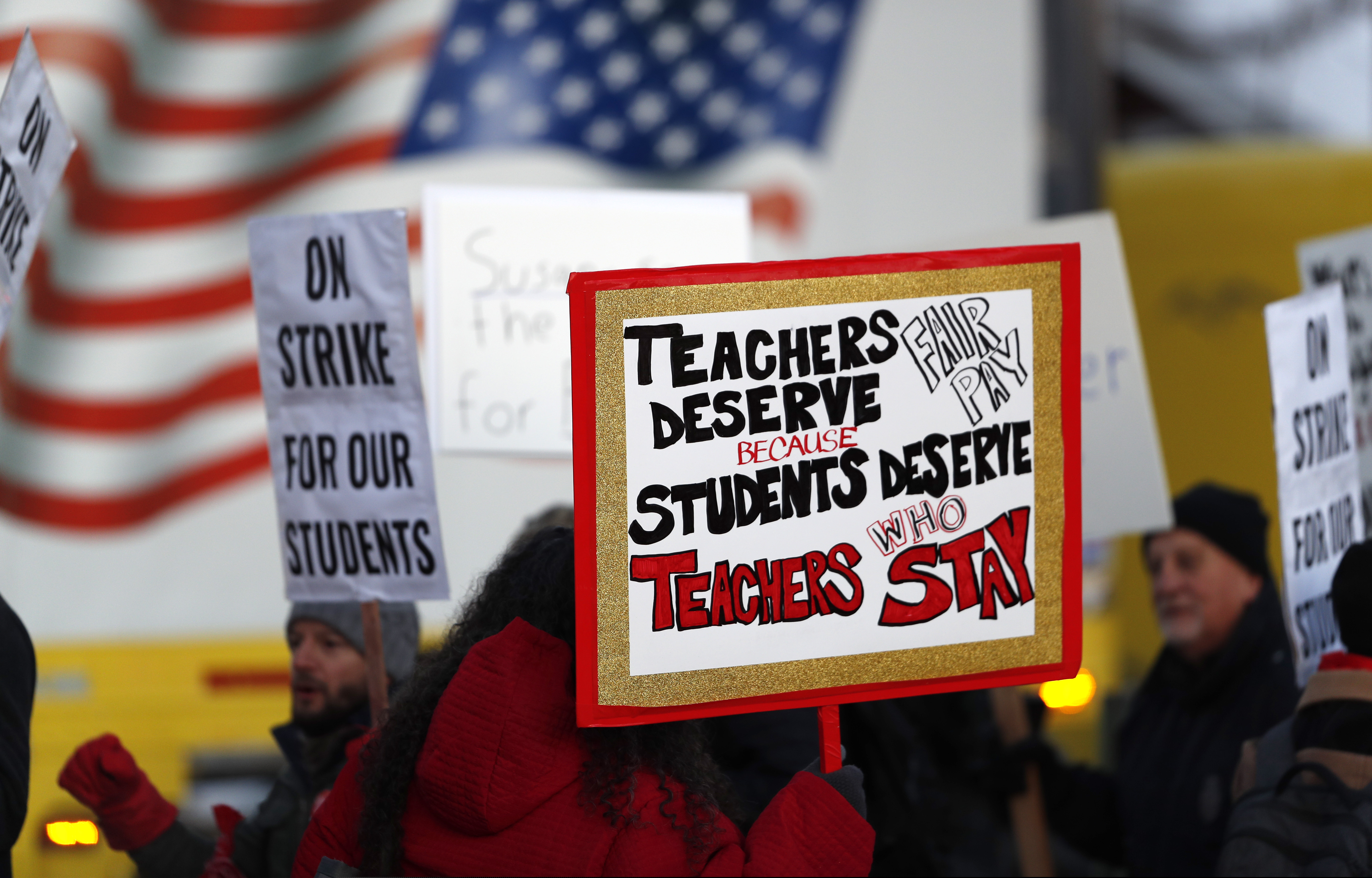 Teachers carry placards as they walk a picket line outside South High School early Monday, Feb. 11, 2019, in Denver. The strike on Monday is the first for teachers in Colorado in 25 years after failed negotiations with the school district over base pay. (AP Photo/David Zalubowski)