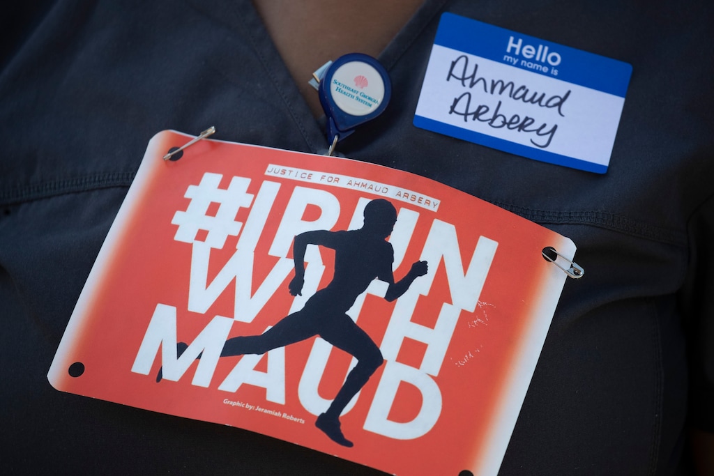 (John Bazemore | AP photo)
A woman displays a sign during a rally to protest the shooting of Ahmaud Arbery, an unarmed black man Friday, May 8, 2020, in Brunswick Ga. Two men have been charged with murder in the February shooting death of Arbery, whom they had pursued in a truck after spotting him running in their neighborhood.