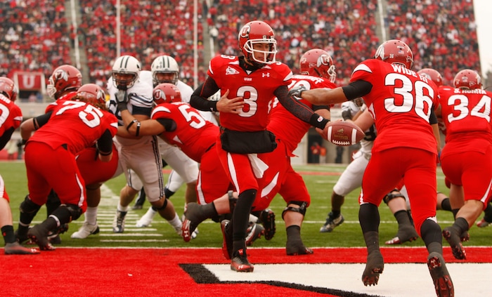 (Trent Nelson  |  Tribune file photo)  Utah Utes quarterback Jordan Wynn #3 hands the ball to Utah Utes running back Eddie Wide #36 as the Utes face BYU in the first quarter at Rice-Eccles Stadium Saturday, November 27, 2010.