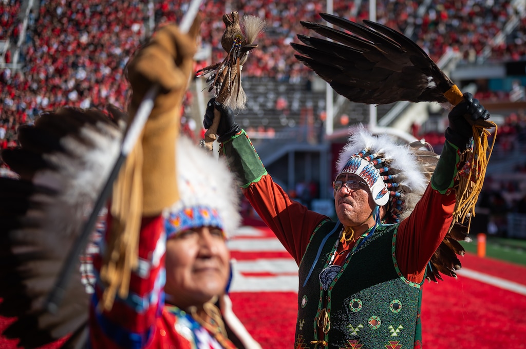 (James Roh | Special to The Tribune) Sapianaze LaRose, right, and Henry Howell, members of the Ute Tribe, wave to the crowd after performing during the halftime of a football game at Rice-Eccles Stadium in 2023.