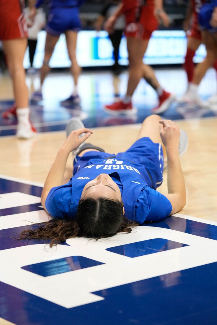 (Francisco Kjolseth | The Salt Lake Tribune)BYU Cougars guard Kaylee Smiler (11) remains on the floor a little bit longer after taking a tumble on a basket attempt in basketball action between the Utah Utes and the Brigham Young Cougars, at the Marriott Center in Provo, on Saturday, Dec. 10, 2022.