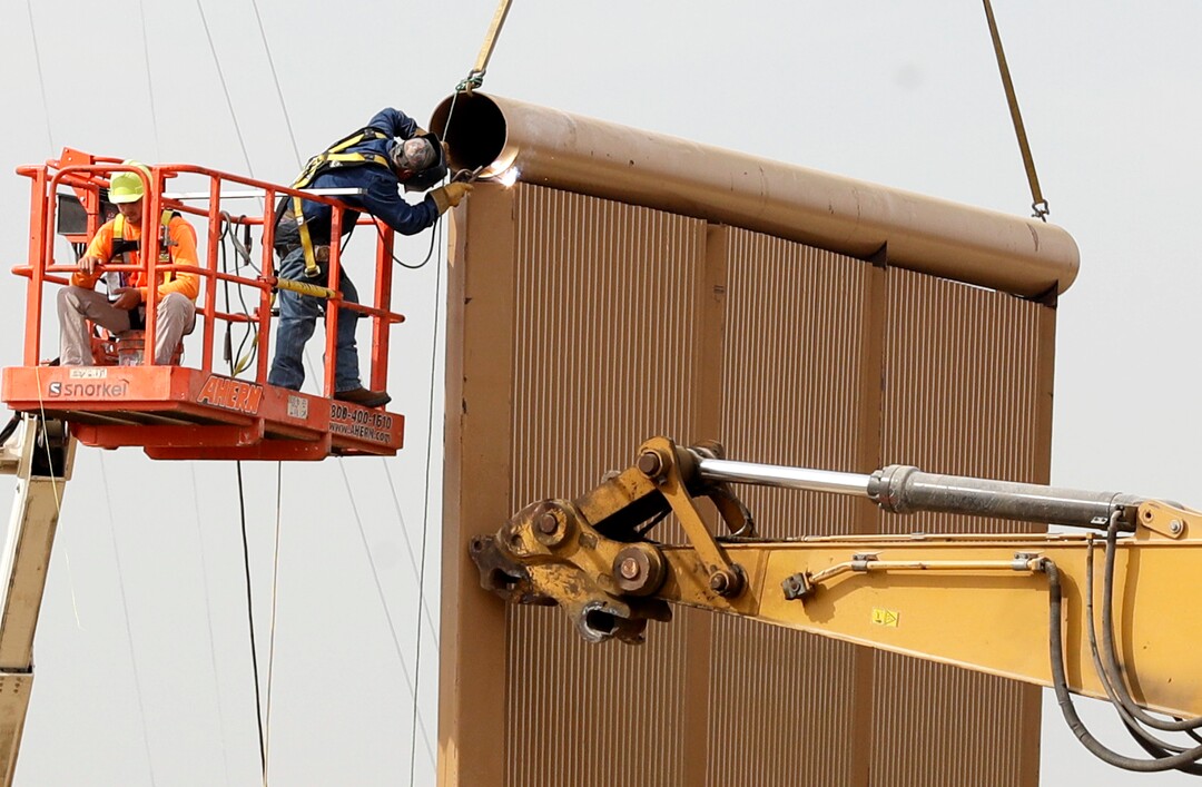 (Gregory Bull | Associated Press file photo)  In this Oct. 19, 2017 file photo, crews work on a border wall prototypes near the border with Tijuana, Mexico, in San Diego. A U.S. official says recent testing of prototypes of President Donald Trump's proposed wall with Mexico found their heights should stop border crossers. U.S. tactical teams spent three weeks trying to breach and scale the models in San Diego. An official with direct knowledge of the results said they point to see-through steel barriers topped by concrete as the best design. The official spoke to The Associated Press on condition of anonymity because the information is not authorized for release.