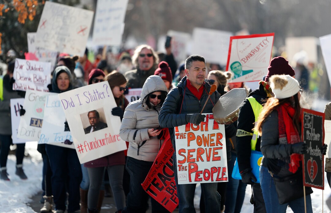 Teachers carry placards as they march along Speer Boulevard from West High School Monday, Feb. 11, 2019, in Denver. The strike is the first for teachers in Denver since 1994 and centers on base pay. (AP Photo/David Zalubowski)