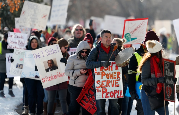 Teachers carry placards as they march along Speer Boulevard from West High School Monday, Feb. 11, 2019, in Denver. The strike is the first for teachers in Denver since 1994 and centers on base pay. (AP Photo/David Zalubowski)