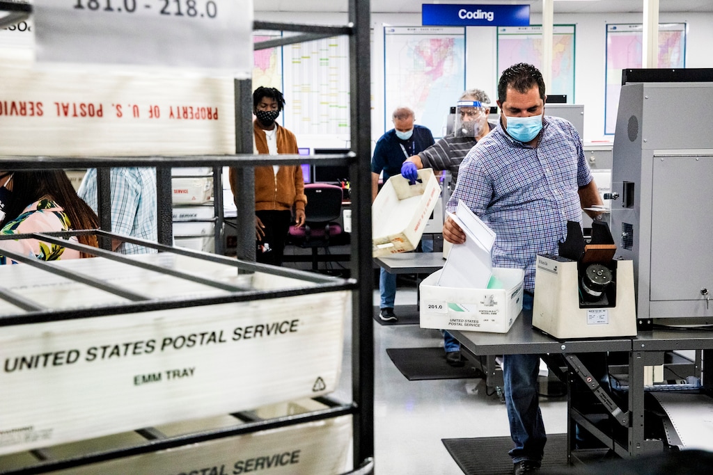 (Scott McIntyre | The New York Times) Election workers process mail-in ballots for Florida's primary election in Doral, Fla., Aug. 18, 2020. Voters are facing a deluge of misinformation about voting by mail, some prompted by the president. Here's a guide to those false claims.