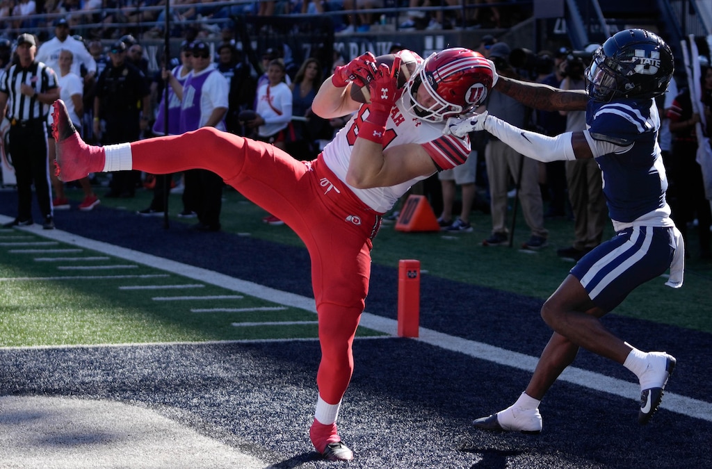 (Francisco Kjolseth  | The Salt Lake Tribune) Utah Utes tight end Caleb Lohner (84) scores a touchdown as Utah State Aggies cornerback JD Drew (3) defends him during a game in 2024. The Utes and Aggies have agreed to a new home-and-home series.
