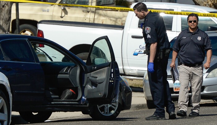 (Francisco Kjolseth | The Salt Lake Tribune) A bullet hole can be seen in the windshield of a black sedan as Investigators comb the scene where a Granite School District police officer shot a driver on Tuesday afternoon, March 20, 2018. While on patrol near Hunter High School, the officer noticed a car full of teenagers and smelled marijuana. When he approached the car lurched and he ended up on the hood. The driver was shot and four other teens in the car fled the scene.
