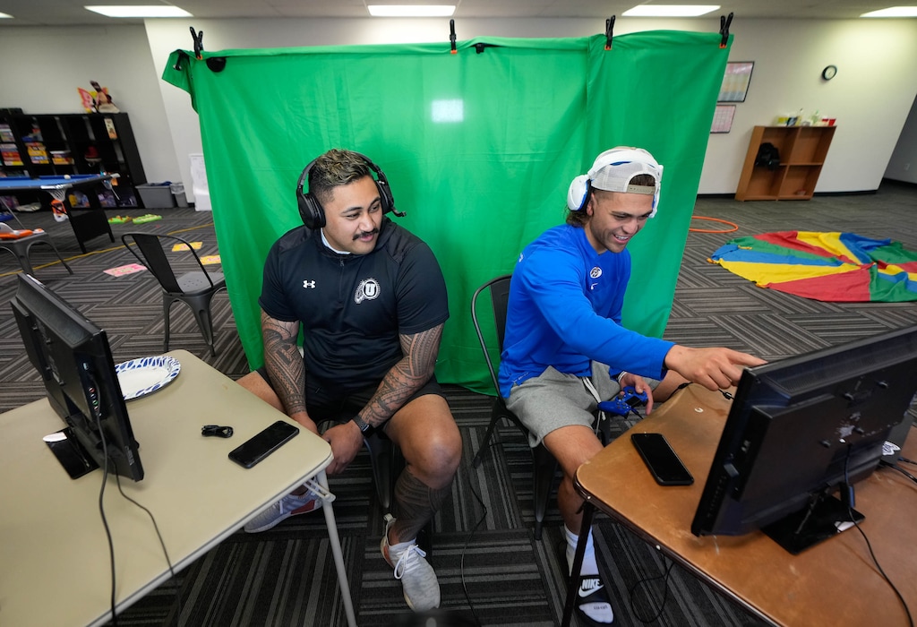 (Francisco Kjolseth | The Salt Lake Tribune) Isaac Asiata, left, a former center for Utah is sits next to BYU running back Lopini Katoa as they compete in a video game challenge in Orem, Utah on Saturday, May 21, 2022, for the name, image and likeness (NIL) collective, Coug Connect, an early stage NIL collective for BYU to create financial opportunities for athletes. 