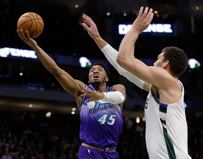 Utah Jazz's Donovan Mitchell (45) shoots against Milwaukee Bucks' Brook Lopez during the second half of an NBA basketball game Monday, Nov. 25, 2019, in Milwaukee. (AP Photo/Aaron Gash)