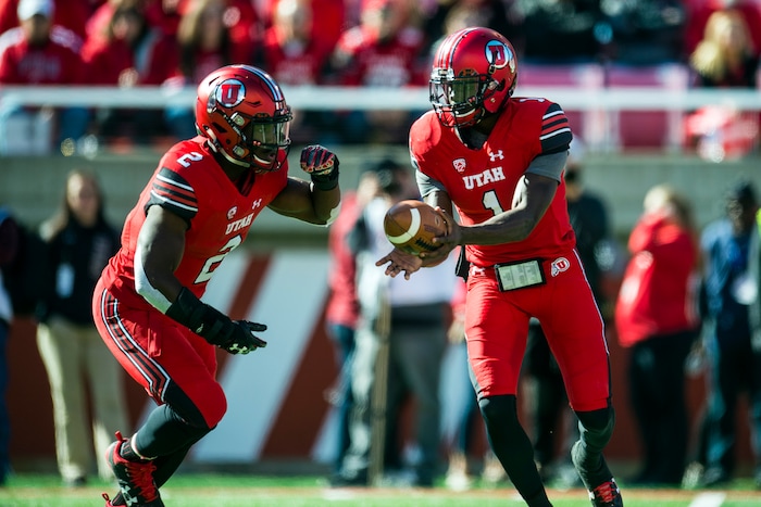 (Chris Detrick  |  The Salt Lake Tribune)  Utah Utes quarterback Tyler Huntley (1) hands off to Utah Utes running back Zack Moss (2) during the game at Rice-Eccles Stadium Saturday, October 21, 2017. 
