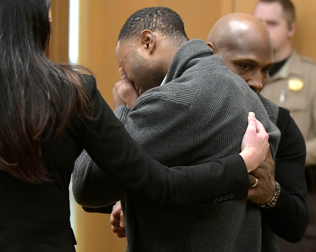 Torrey Green cries while being consoled by defense attorney Skye Lazaro, left, and private investigator E. Christian Warmsley as a jury finds him guilty of eight charges including five counts of rape and a charge sexual battery in connection to reports from six women accusing him of sexual assault while he was a football player at Utah State University, Friday, Jan.18, 2019 in Brigham City, Utah. (Eli Lucero/Herald Journal via AP)