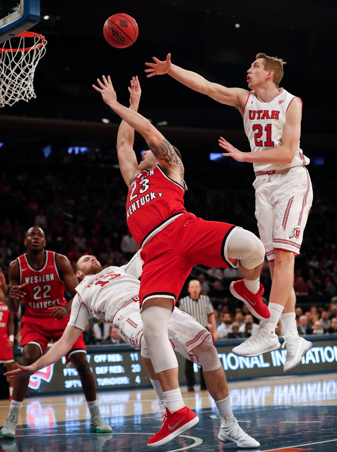 Utah forward David Collette (13) draws an offensive foul on Western Kentucky forward Justin Johnson (23) as Utah forward Tyler Rawson (21) helps defend during the second half of an NCAA college basketball game during the semifinals of the NIT, Tuesday, March 27, 2018, in New York. Utah won 69-64. (AP Photo/Julie Jacobson)