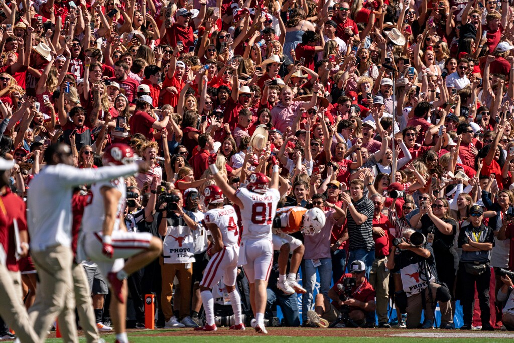 (Jeffrey McWhorter | AP) Oklahoma fans celebrate the game-winning touchdown reception by wide receiver Nic Anderson (4) at the Cotton Bowl on Saturday. Oklahoma won 34-30.