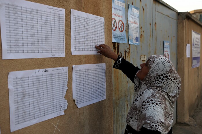 An Iraqi Kurdish woman checks for her name shortly before opening the polling centers for the referendum on independence from Iraq in Irbil, Iraq, Monday, Sept. 25, 2017. (AP Photo/Khalid Mohammed)