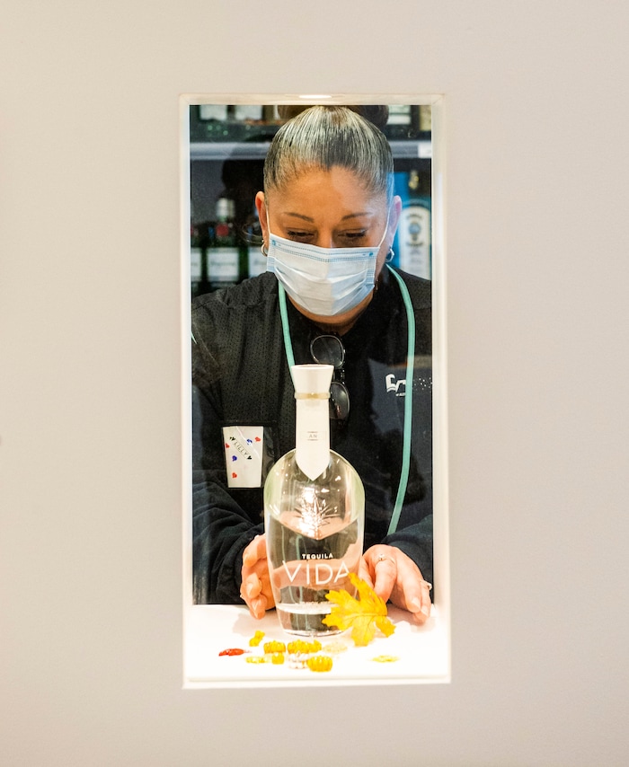 (Rick Egan | The Salt Lake Tribune)  Lilly Rodriguez arranges a bottle in the premium products room before the opening of the new state liquor and wine store in Saratoga Springs, on Monday, Nov. 16, 2020.