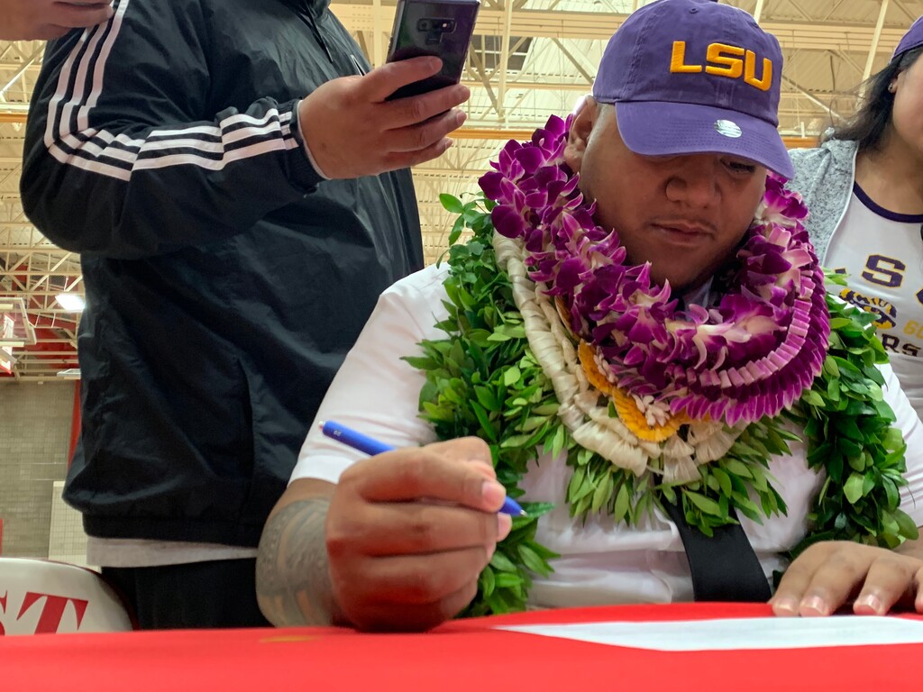 (Alex Vejar  |  The Salt Lake Tribune)  Siaki Ika of East High School signs his national letter of intent to play football at Luisiana State University on Wednesday in the high school’s gym.