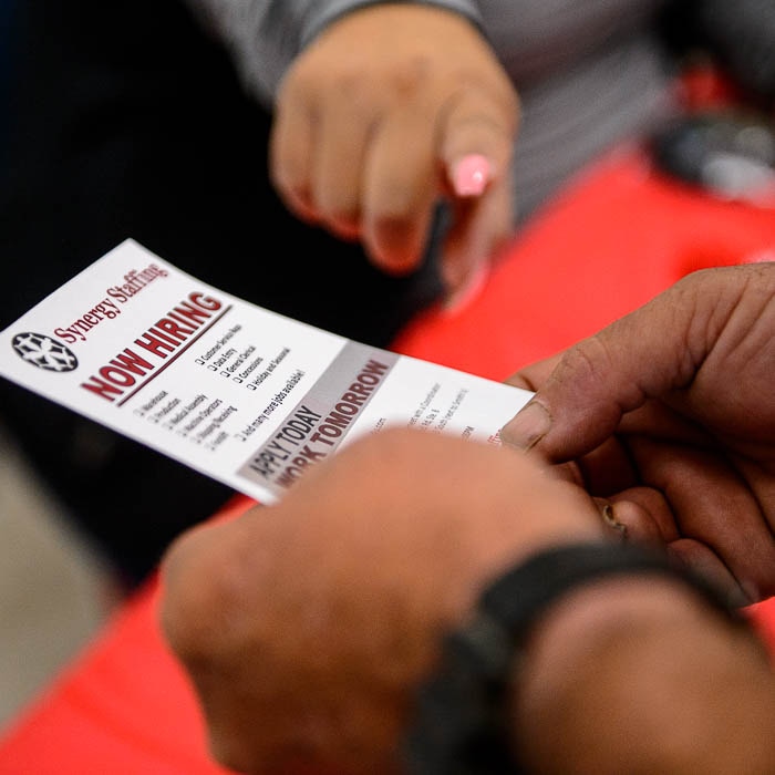 (Trent Nelson | Tribune photo)  Applicant takes information at a job fair hosted by Catholic Community Services at the Weigand Center in Salt Lake City, Aug. 21, 2018.