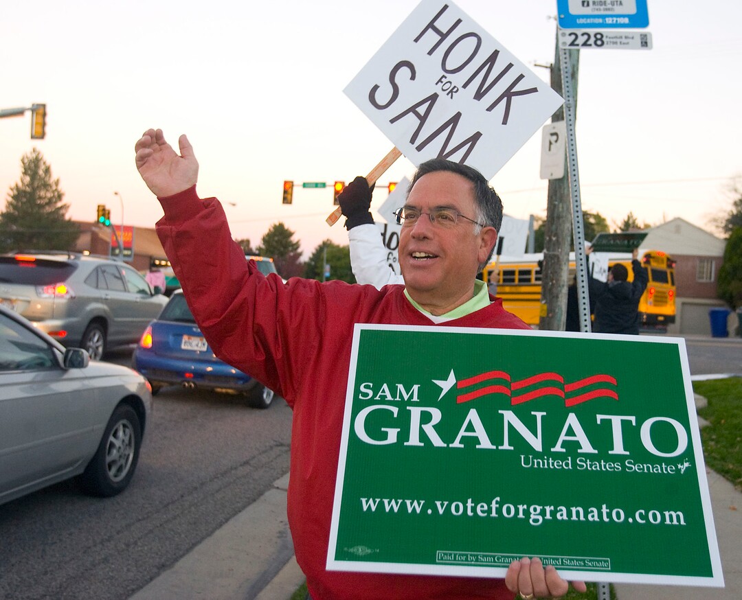 (Al Hartmann  |  Tribune File Photo)  Democratic candidate for U.S. Senate Sam Granato waves at cars along Foothill Drive and 1300 South on Tuesday morning as people make their way to work and vote.