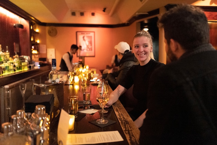 In this Dec. 27, 2019, photo, Ketija Feldmane talks with Alberto Paolino as they sit in B Flat, a Japanese jazz bar in New York. The couple from Milan researched speakeasies before spending a week's vacation in New York. Although not originally a speakeasy, B Flat is a secretive basement bar downstairs from an unmarked street level door in the Tribeca neighborhood. (AP Photo/Mark Lennihan)