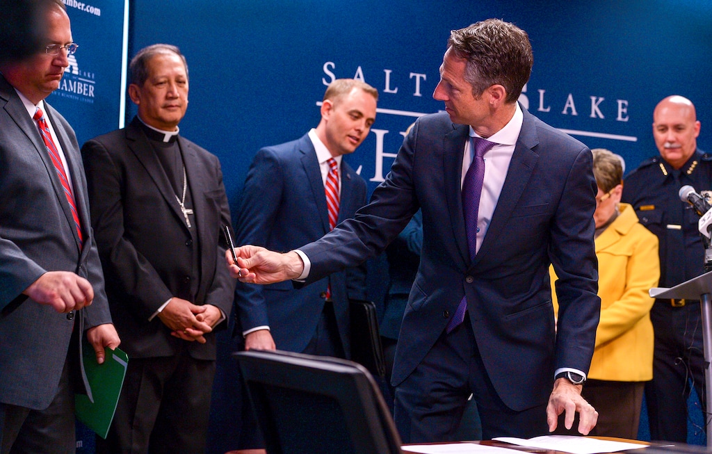 (Leah Hogsten | The Salt Lake Tribune) Derek Miller, right, president and CEO of the Salt Lake Chamber, passes a pen to the city's business and civic leaders who gathered Thursday to sign the Utah Compact, initially adopted in 2010. The compact emphasizes humane treatment of immigrants, keeping families together and focusing deportation on serious criminals.