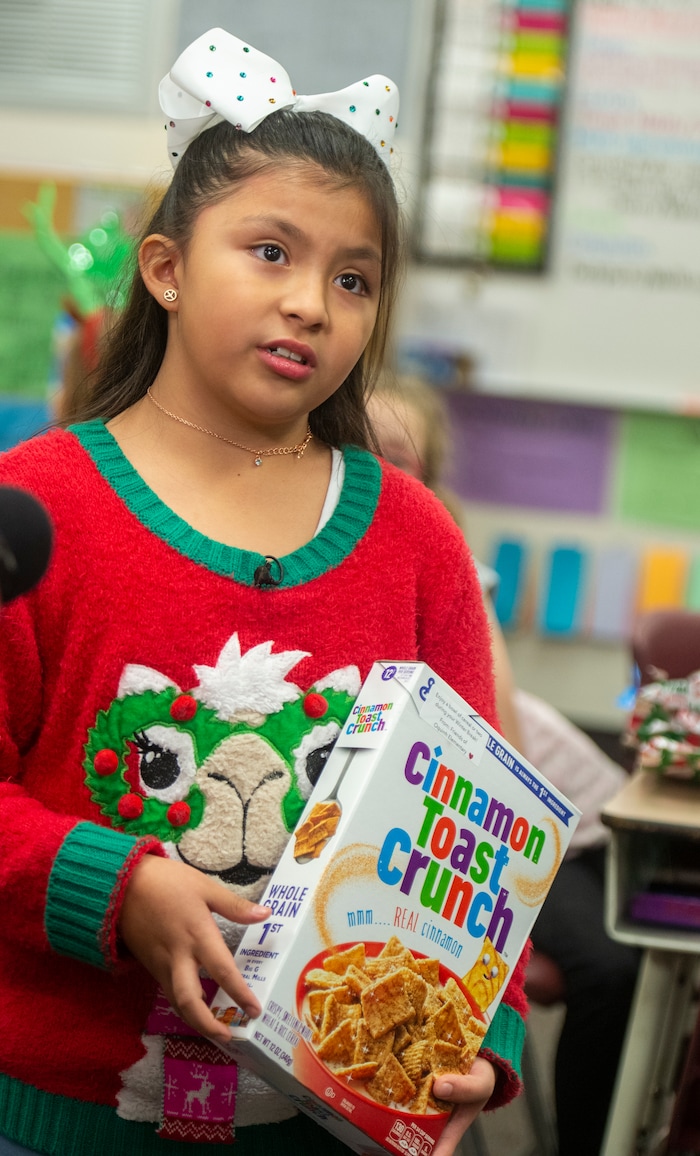 (Rick Egan  |  The Salt Lake Tribune)  Third grader Victoria Harwood, holds her box of cereal as she gives an interview to the media. Ms. Worthington the principal, surprised all 650 students at her school with the gift-wrapped boxes of cereal, at Oquirrh Elementary in West Jordan, Thursday, Dec. 20, 2018.


