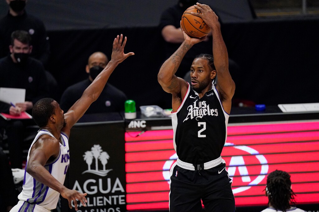 Los Angeles Clippers forward Kawhi Leonard, right, shoots as Sacramento Kings forward Harrison Barnes defends during the first half of an NBA basketball game Sunday, Feb. 7, 2021, in Los Angeles. (AP Photo/Mark J. Terrill)