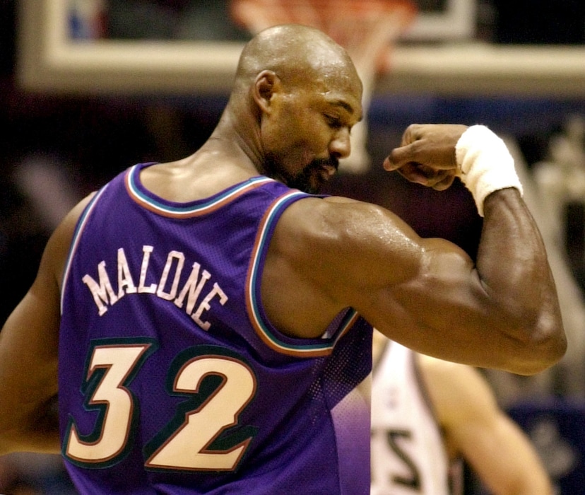 ** FILE ** Utah Jazz forward Karl Malone displays his muscle to the New Jersey Nets fans after leading all scorers with 31 points as the Jazz beat the Nets 104-90 Saturday night, Dec. 22, 2001, in East Rutherford, N.J. Malone, who for 18 seasons as a member of the Utah Jazz teamed with guard John Stockton to form one of the NBA's most legendary duos, will announce his retirement on Sunday, the Jazz said in a news release Friday. (AP Photo/Bill Kostroun)
