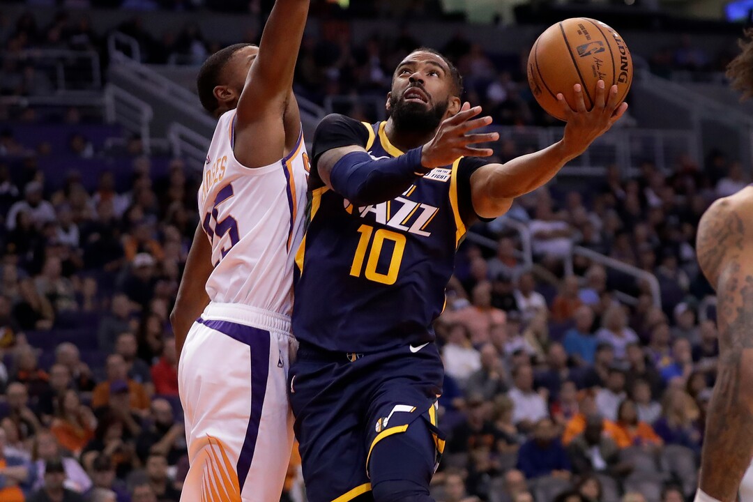 Utah Jazz guard Mike Conley (10) shoots around Phoenix Suns forward Mikal Bridges during the first half of an NBA basketball game, Monday, Oct. 28, 2019, in Phoenix. (AP Photo/Matt York)