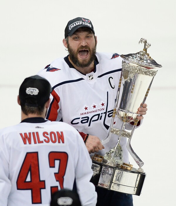Washington Capitals right wing Tom Wilson (43) watches as left wing Alex Ovechkin celebrates while holding the Prince of Wales trophy after the Capitals defeated the Tampa Bay Lightning 4-0 in Game 7 of the NHL Eastern Conference finals hockey playoff series Wednesday, May 23, 2018, in Tampa, Fla. (AP Photo/Jason Behnken)