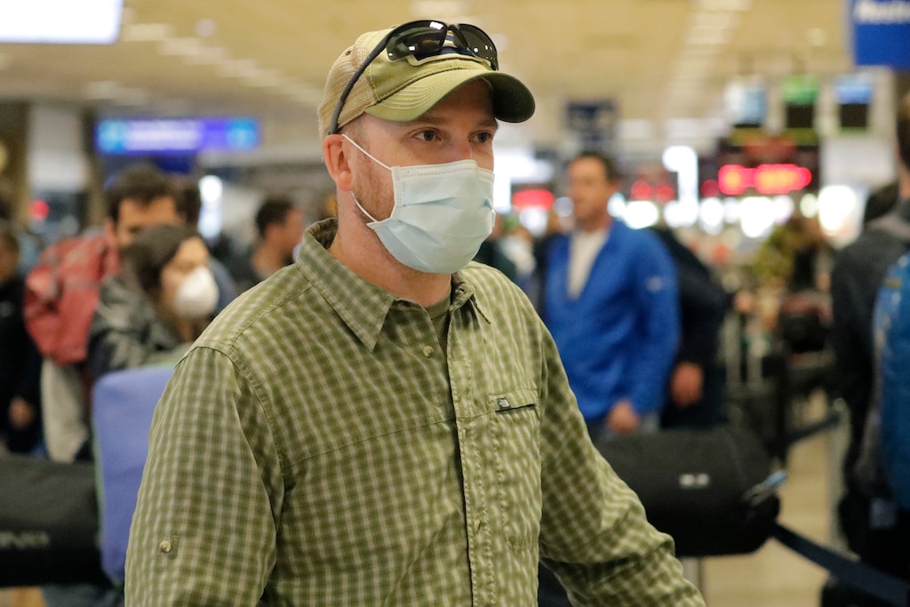 (Rick Bowmer | AP file photo) A masked traveler stands in line with his luggage before getting to the ticket counter at the Salt Lake City International Airport on Sunday, March 15, 2020 in Salt Lake City.