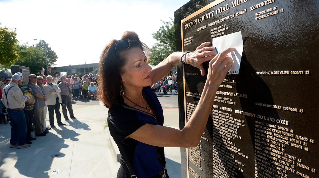 Al Hartmann  |  The Salt Lake TribuneMichelle Goon makes a pencil etching of her little brother's name, James Smith who died in a mining accident on 1/25/1988. He was only 20.  His name is on the Carbon County Coal Miners' Memorial that was unveiled and dedicated Monday September 7 to coal miners that died in accidents since the inception of mining in the 1880's.  Two statues and several large stone plaques with 1,400 names of fallen miners now resides in the Price Peace Park along Main Street. 