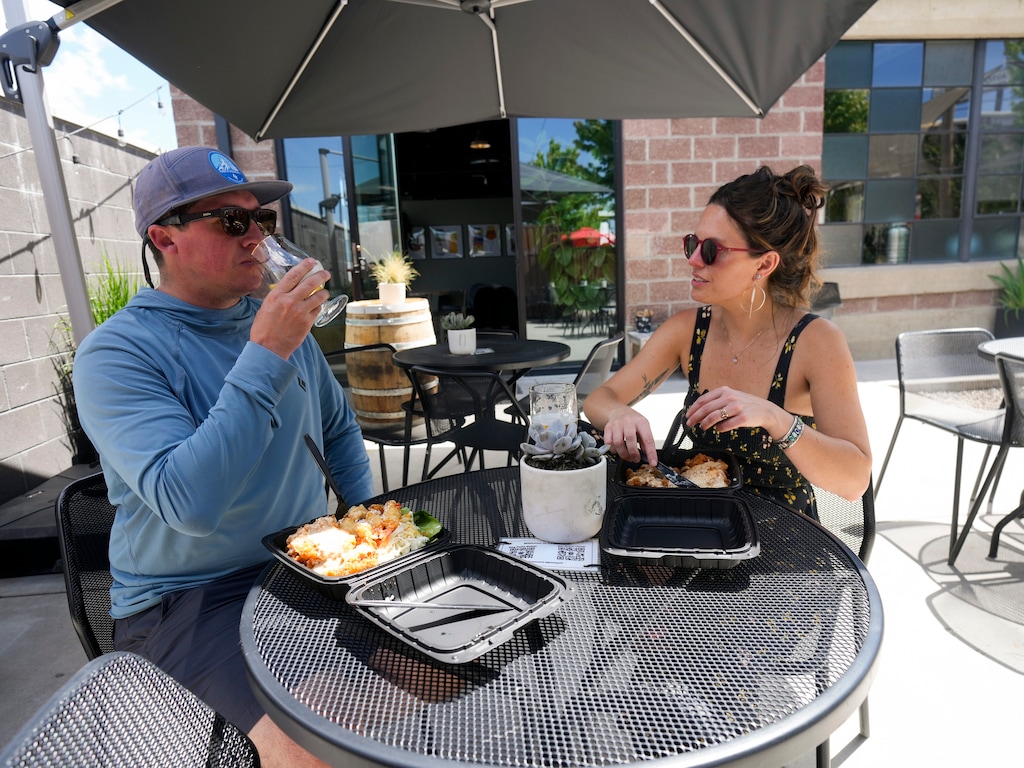 (Bethany Baker  |  The Salt Lake Tribune) Michael Brunker, left, and Kelsie Rook eat lunch on the patio at TF Brewing in Salt Lake City on Friday, May 17, 2024.