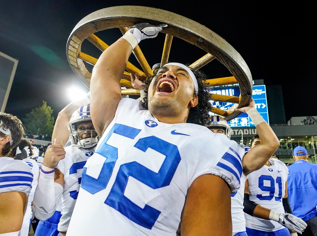 (Leah Hogsten | The Salt Lake Tribune) Brigham Young Cougars offensive lineman Joe Tukuafu (52) celebrates the win as the Utah State Aggies host Brigham Young University Cougars at Maverik Stadium Oct. 1, 2021. The Cougars attempt a second straight win for the Wagon Wheel, the trophy of the in-state rivalry, while the Aggies will try to recapture the trophy.